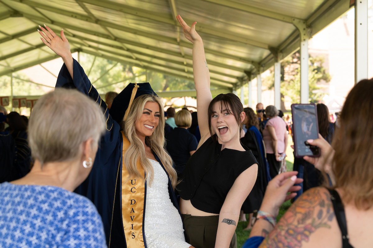 Parent taking photo of graduate.