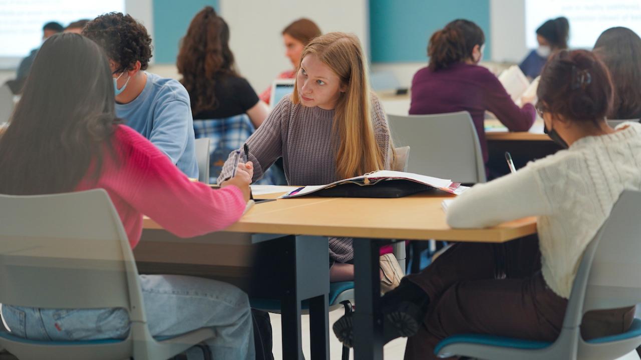 Students studying and writing at desk.
