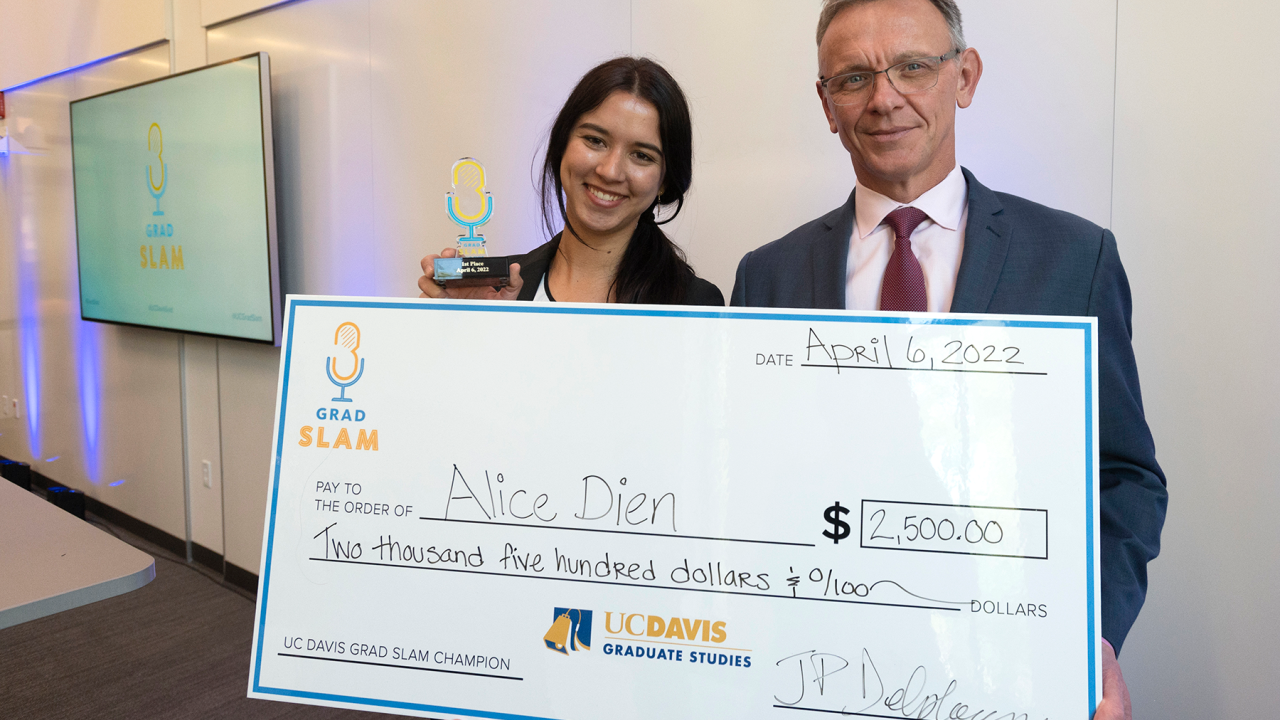Alice Dien and Dean Jean Pierre Delplanque with an oversized winner's check.