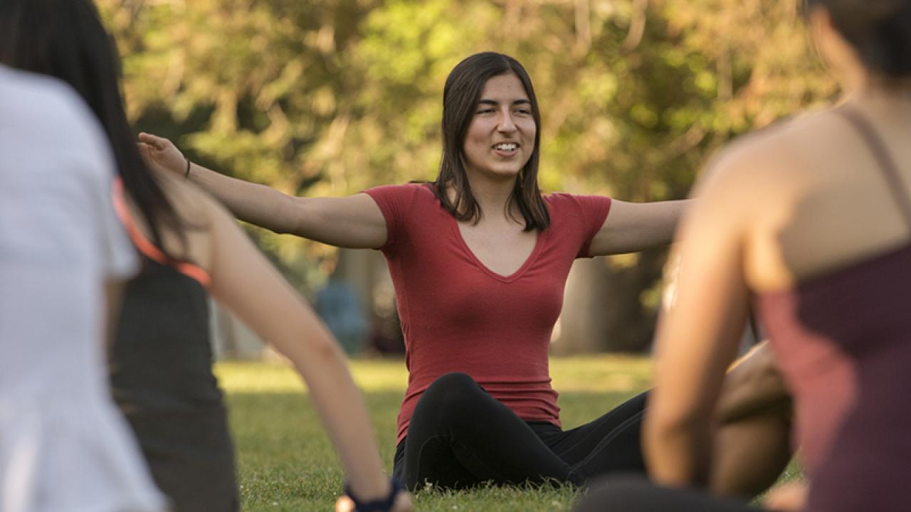 individual instructing students in yoga outdoors