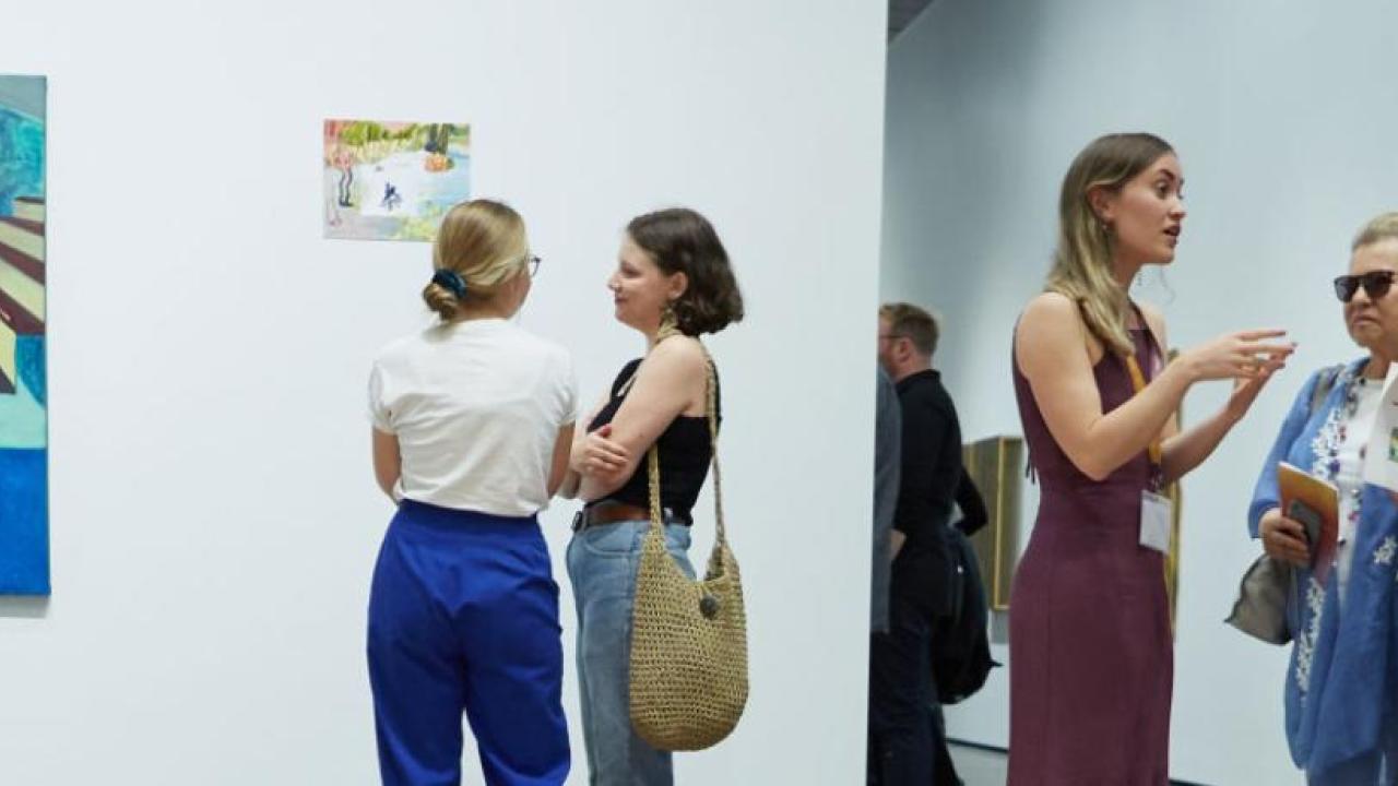 Guests gather in front of art exhibit at the Manetti Shrem Museum of Art