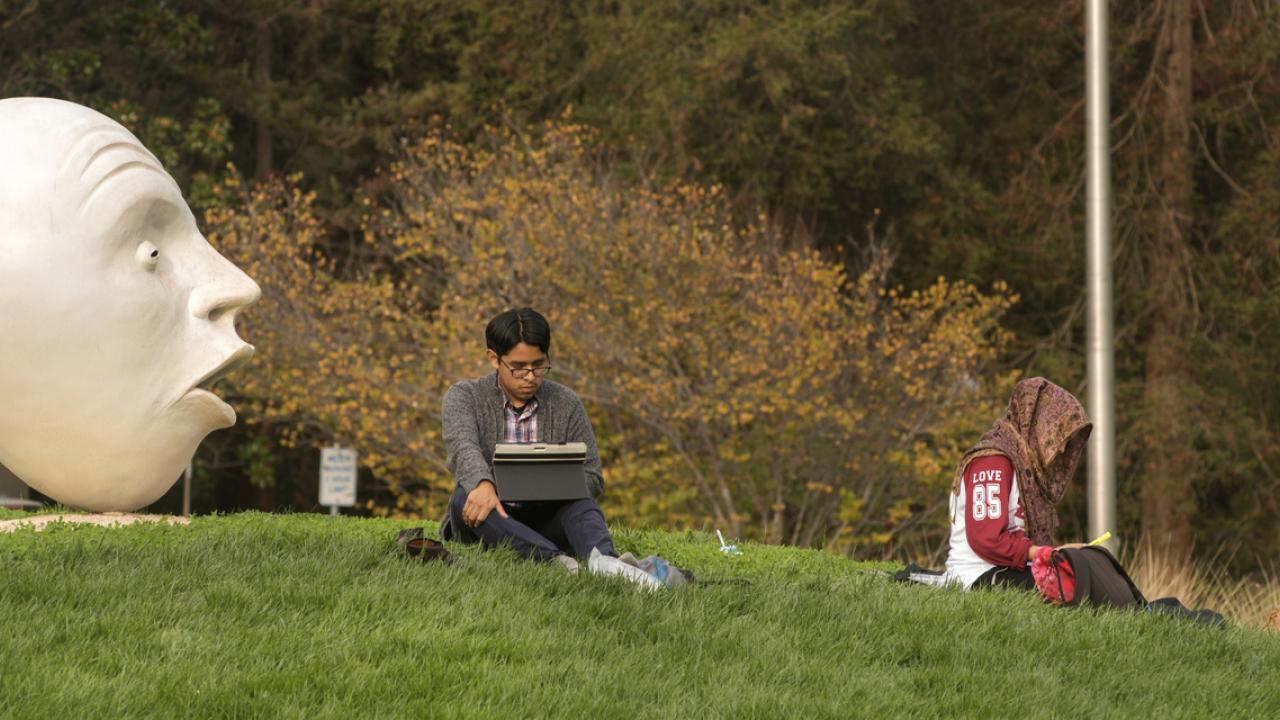 UC Davis graduate students studying by Egghead sculpture