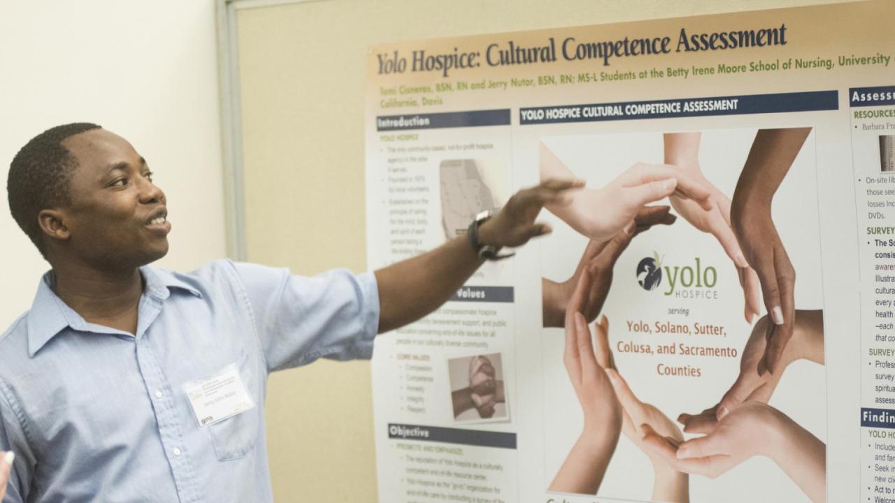 Graduate student presenting at a poster session