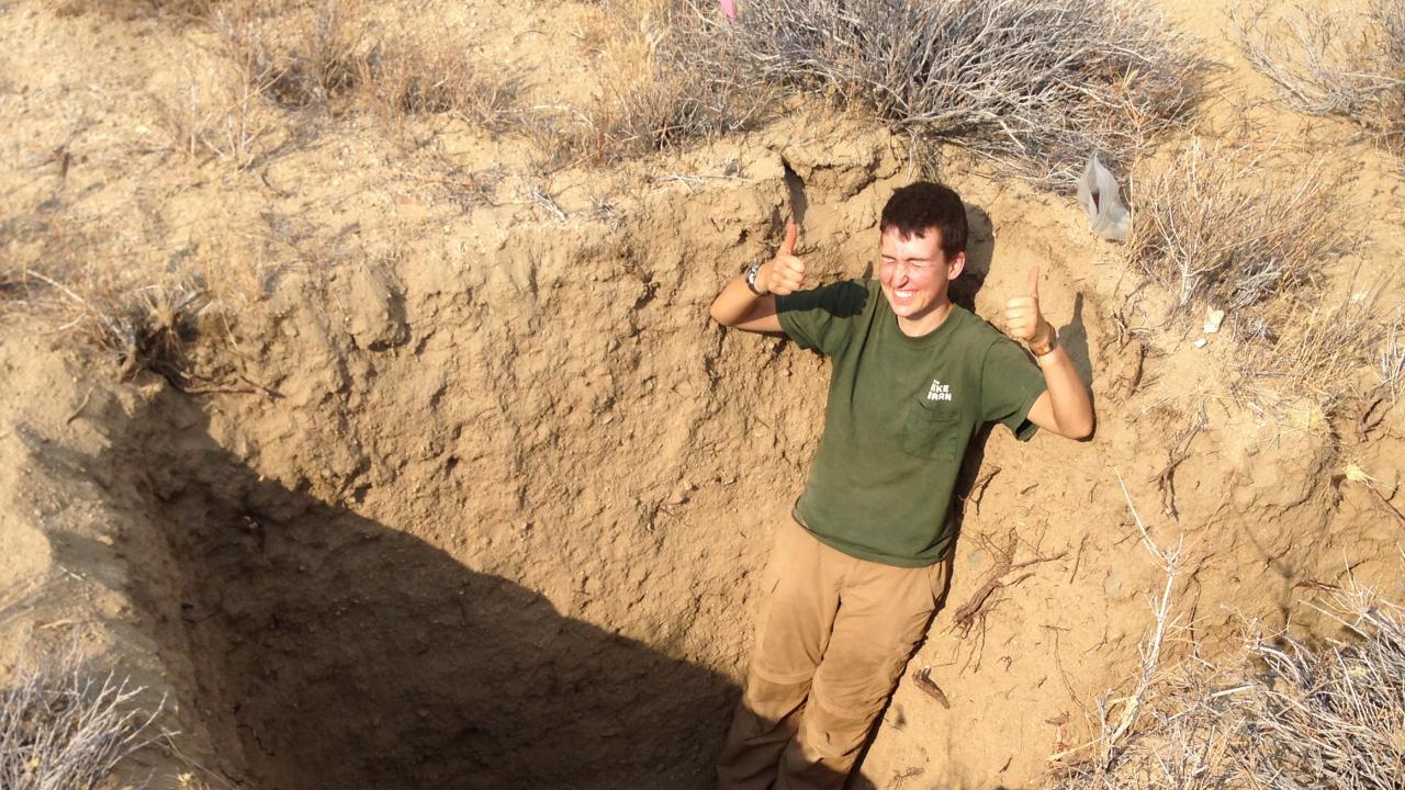 UC Davis graduate student Emery Anderson-Merritt in a hole in the ground