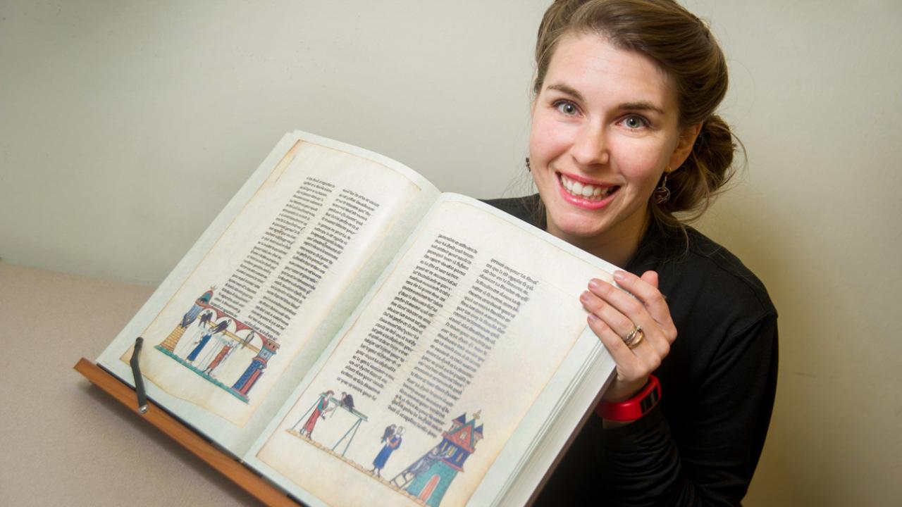 Sara Petrosillo with a 700-year-old manuscript of medieval literature and art.