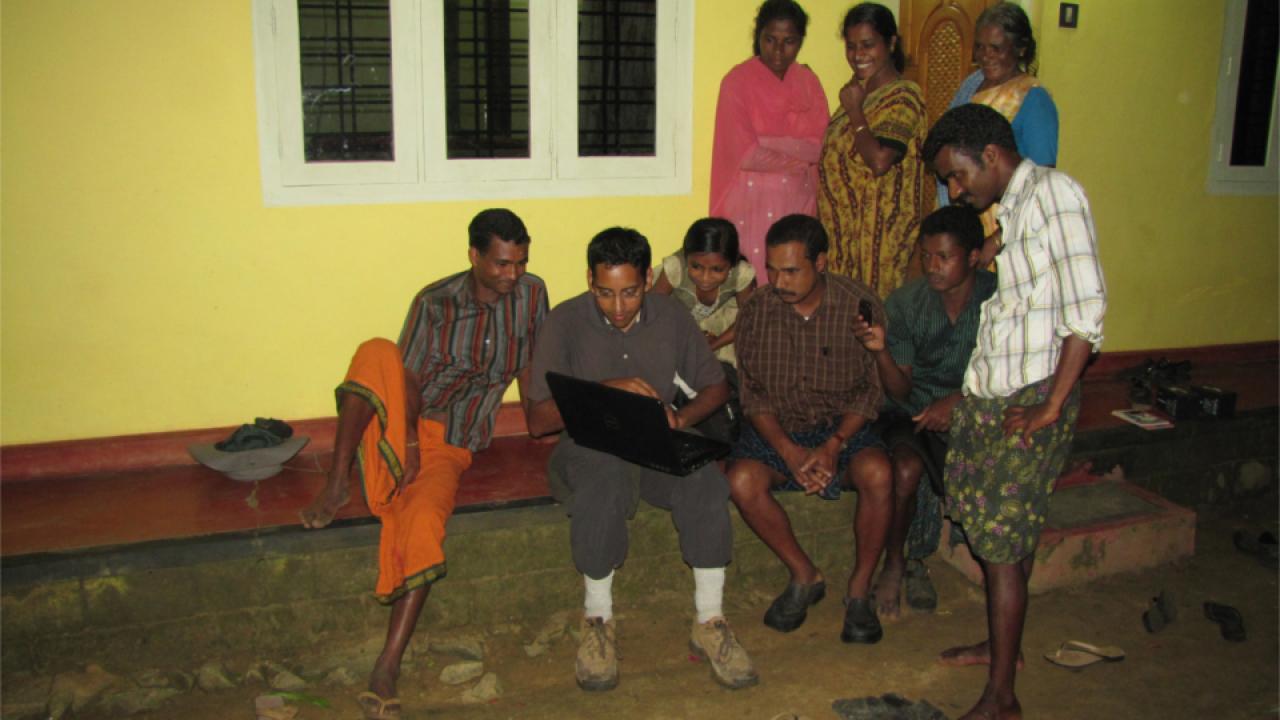 Thuppil (with laptop) shows happy villagers videos of elephants being deterred by playbacks