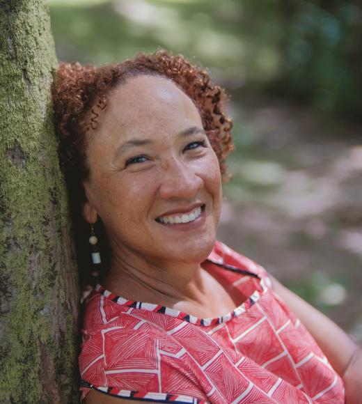 A photo of Dr. Bettina Ng'weno leaning on a tree.