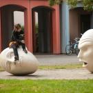 A student sits on an Yin and Yang Egghead and the head appears to look up at her on Tuesday November 27, 2012 at UC Davis.