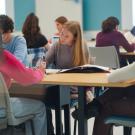 Students studying and writing at desk.