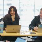 Graduate students smiling with laptops.