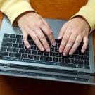 Hands typing on a keyboard.