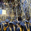 Streamers fall as graduates cheer.