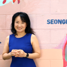 Artist Seongmin Yoo with a small section of her mural featuring aliens at Second and B Streets in downtown Davis. (Maria Sestito/UC Davis)