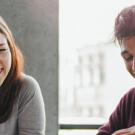 Five diverse coworkers smiling and collaborating at a sunny office table