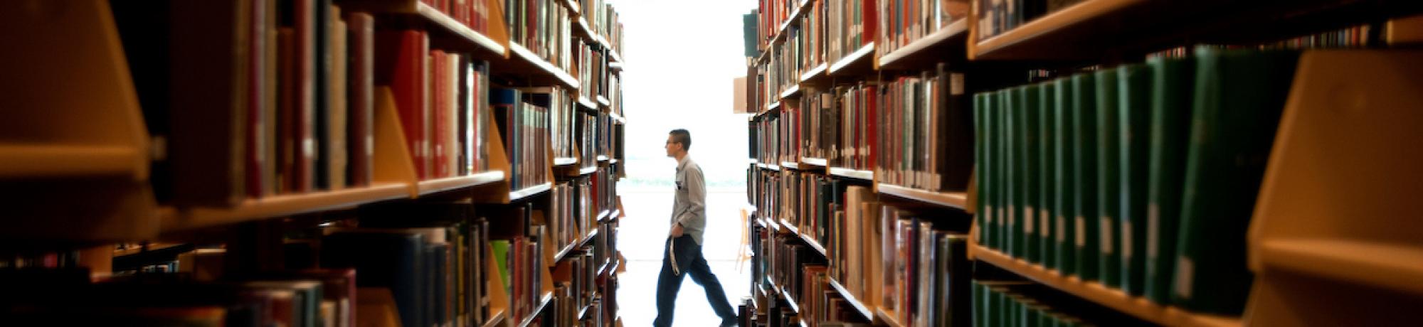 Students walk past aisles of books in  Shields Library on Wednesday October 8, 2014 at UC Davis.